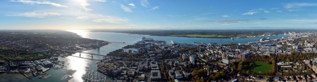 Aerial panorama of Southampton, Hampshire, with River Itchen, bridges, marina, port docks, and city skyline under blue sky
