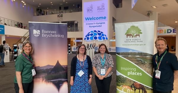 Four health fellows posing with conference banners at the Royal Society of Psychiatry Congress in Cardiff