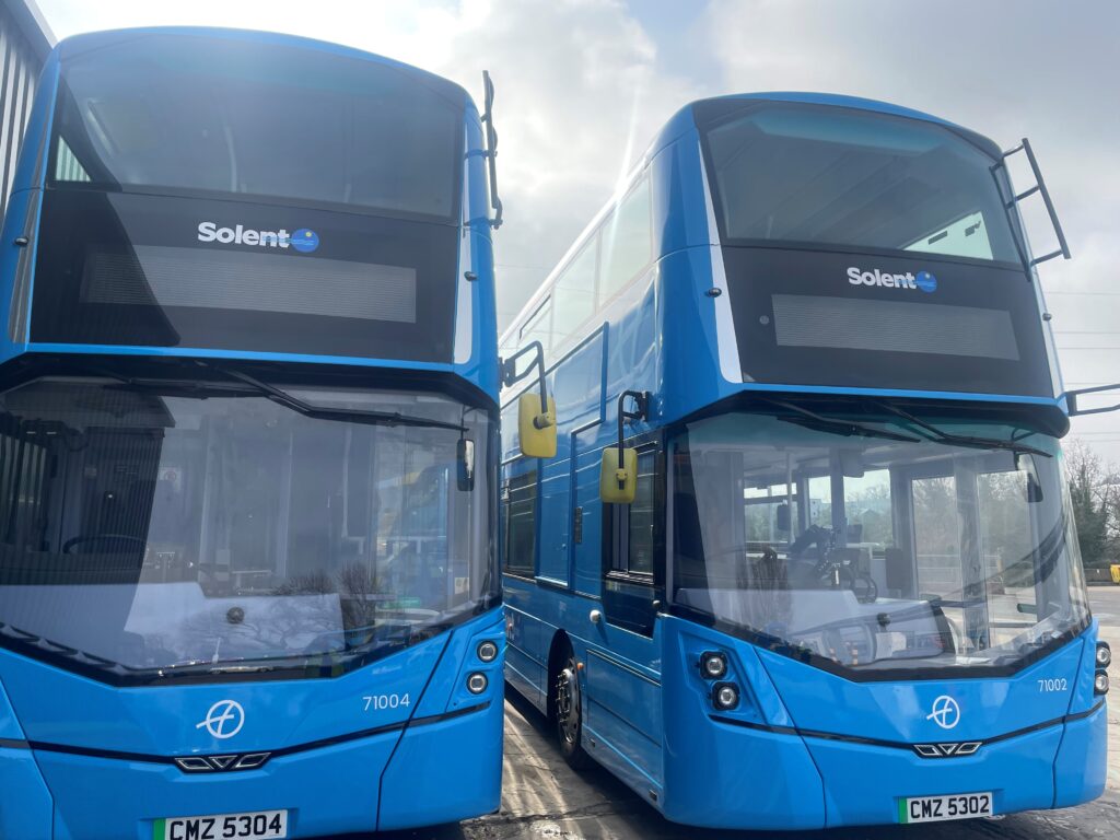 Two blue Solent double-decker buses parked side by side, viewed from the front at a depot